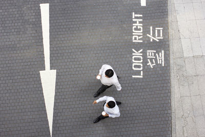 High angle view of two people crossing sign