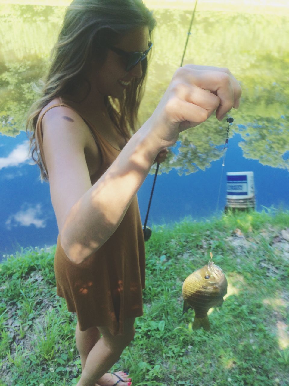 lifestyles, leisure activity, holding, standing, grass, day, person, field, casual clothing, waist up, outdoors, three quarter length, young adult, nature, plant, focus on foreground