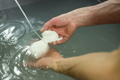 Close-up of hands making cheese