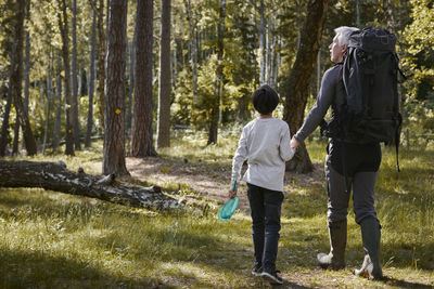 Rear view of people walking in forest