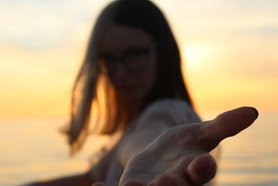 Close-up portrait of woman on beach during sunset