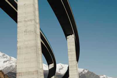 Low angle view of bridge against clear blue sky