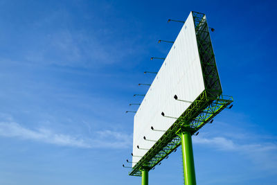 Low angle view of traditional windmill against blue sky