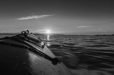 Kayak on sea against sky during sunset