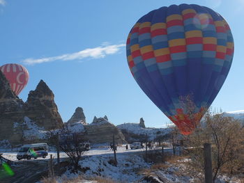 Hot air balloon flying over snow covered land