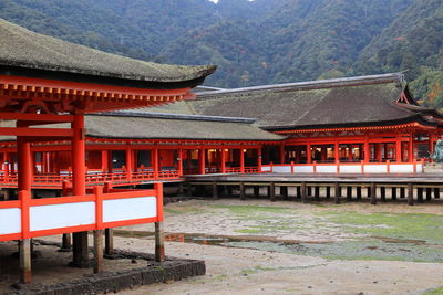 View of shrine by building against mountain