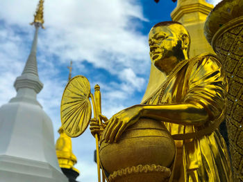 Low angle view of statue against temple against sky