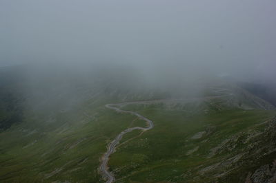 Scenic view of landscape against sky during foggy weather