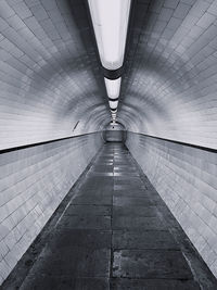 Rear view of man walking in tunnel