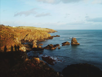 Scenic view of rocks in sea against sky