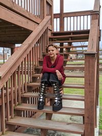 Full length of young woman sitting on staircase