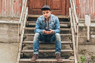 Portrait of young man sitting on staircase