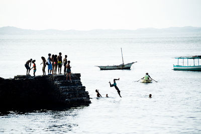 People are seen jumping from the porto da barra pier in the city of salvador, bahia.