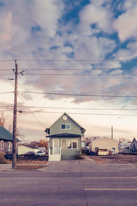 Road amidst buildings against sky at dusk