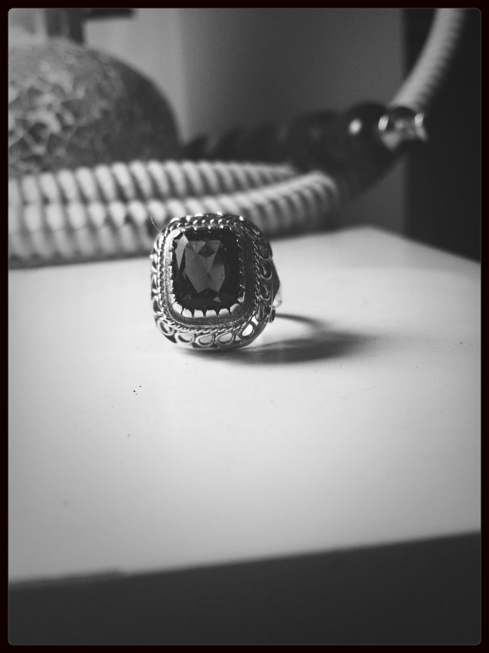 indoors, transfer print, close-up, person, auto post production filter, part of, focus on foreground, selective focus, ring, table, technology, holding, human finger, fashion, cropped, still life, single object