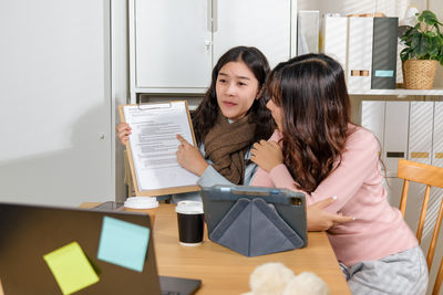 Young woman using digital tablet while sitting at home