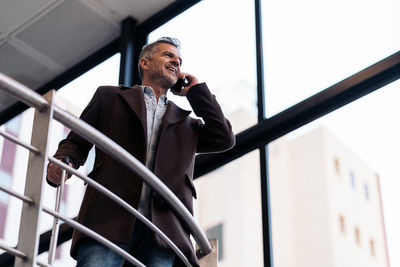 Man looking at camera while standing on railing