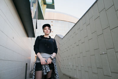 Portrait of young man standing against building
