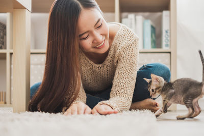 Portrait of young woman with cat at home