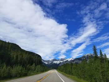 Road by mountains against sky