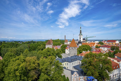 High angle view of gothic church amidst old historic townscape against blue sky