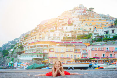 Portrait of smiling woman against buildings in city