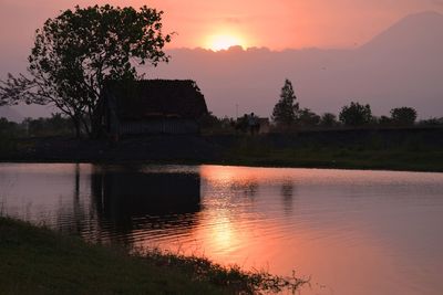 Scenic view of lake against orange sky