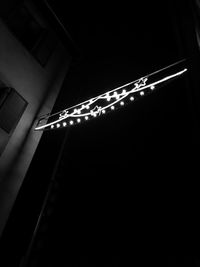 Low angle view of illuminated lights against sky at night