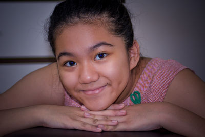 Close-up portrait of a smiling young woman lying at home