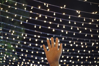 Midsection of person with illuminated lighting equipment at night