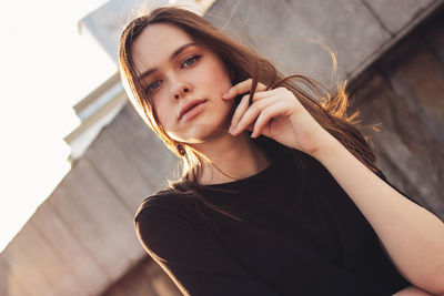 Portrait of beautiful woman against retaining wall