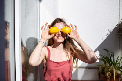 Smiling young woman holding fruits