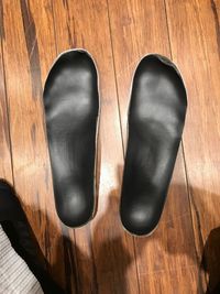 High angle view of black shoes on hardwood floor