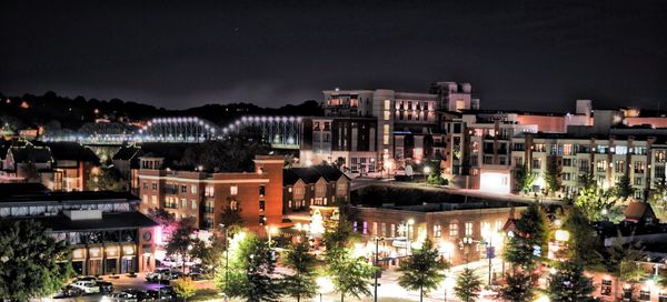 Illuminated cityscape against sky at night