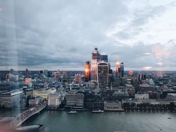 Buildings in city against cloudy sky