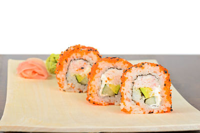 Close-up of sushi on plate against white background