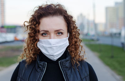 Portrait of a beautiful woman walking down the street wearing a protective mask 