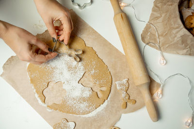 Making christmas gingerbread cookies from dough, holding a mold with your hands