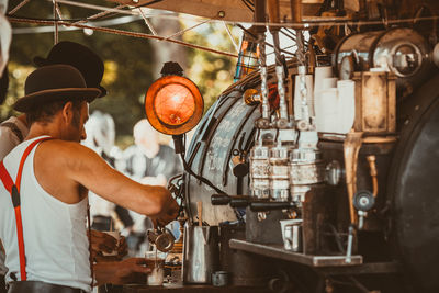 Side view of man preparing coffee
