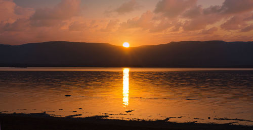 Shore of the dead sea, sunrise over the jordanian mountains. glowing path on the water.