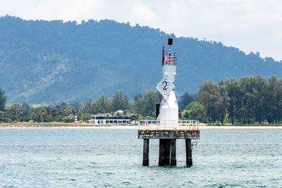 Built structure by sea against sky