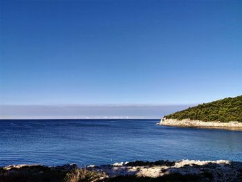 Scenic view of sea against clear blue sky