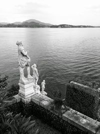 View of statues overlooking rippled water