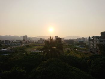 Panoramic view of city buildings against clear sky during sunset