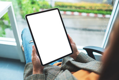 Midsection of woman using digital tablet