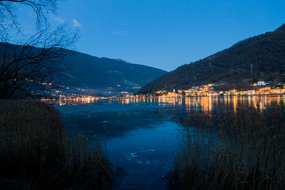 Scenic view of lake against clear sky at dusk