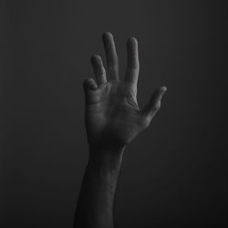 Close-up of human hand against black background