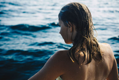 Close-up of young woman at beach against sky