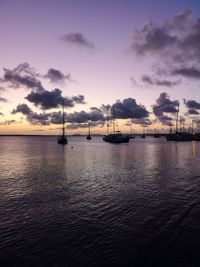 Sailboats in sea at sunset