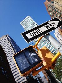 Low angle view of directional sign against buildings in city